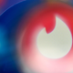 The Tinder app logo on a screen being blurred out by glare.